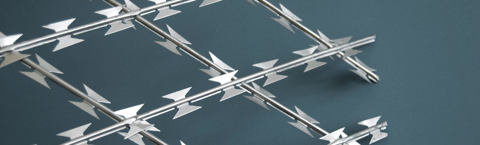 A part of straight razor wire with galvanized finish.